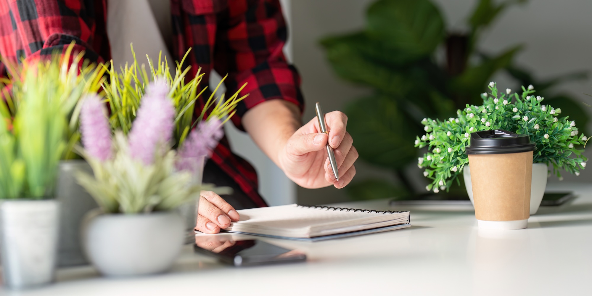 Digital Gardener Planning Plant Care with Notebook and Tech Devices